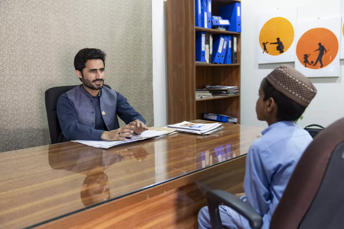 Social Case Worker Kefayatullah speaks to a young boy in his office at the Child Protection Unit in Mingora, Swat district, Khyber Pakhtunkhwa. 