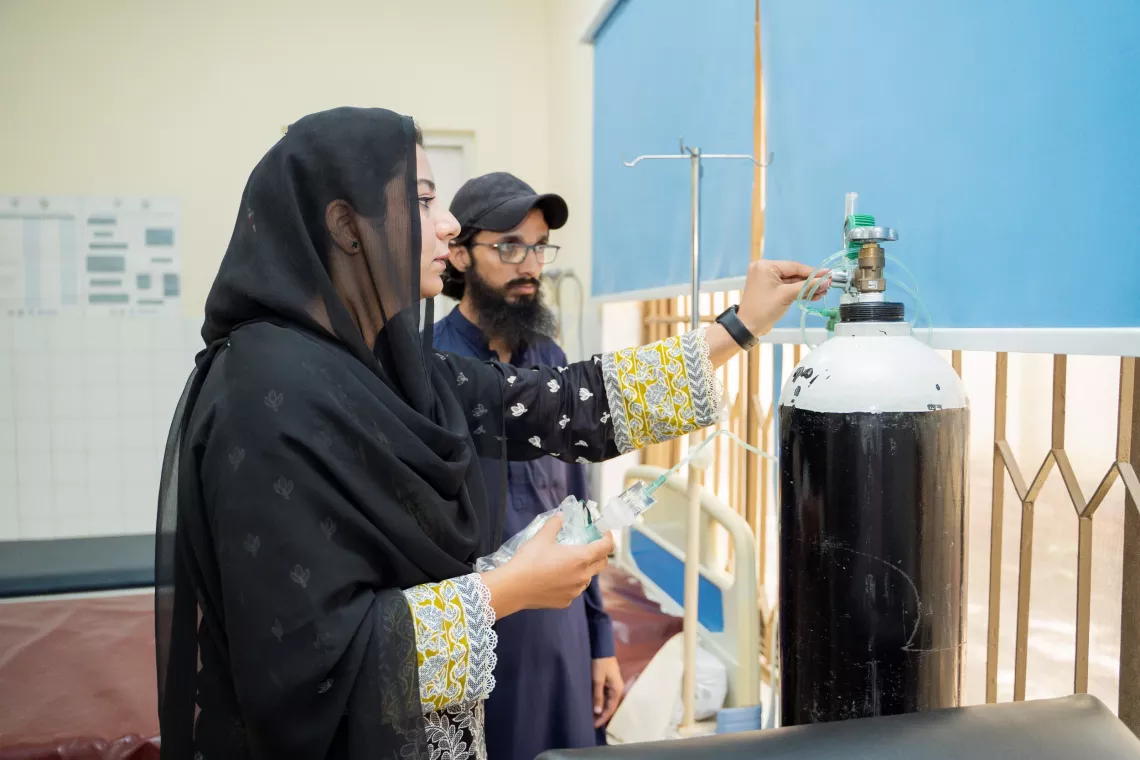 Dr. Samia inspects an oxygen cylinder at the Rural Health Centre in Barakahu, Islamabad. 