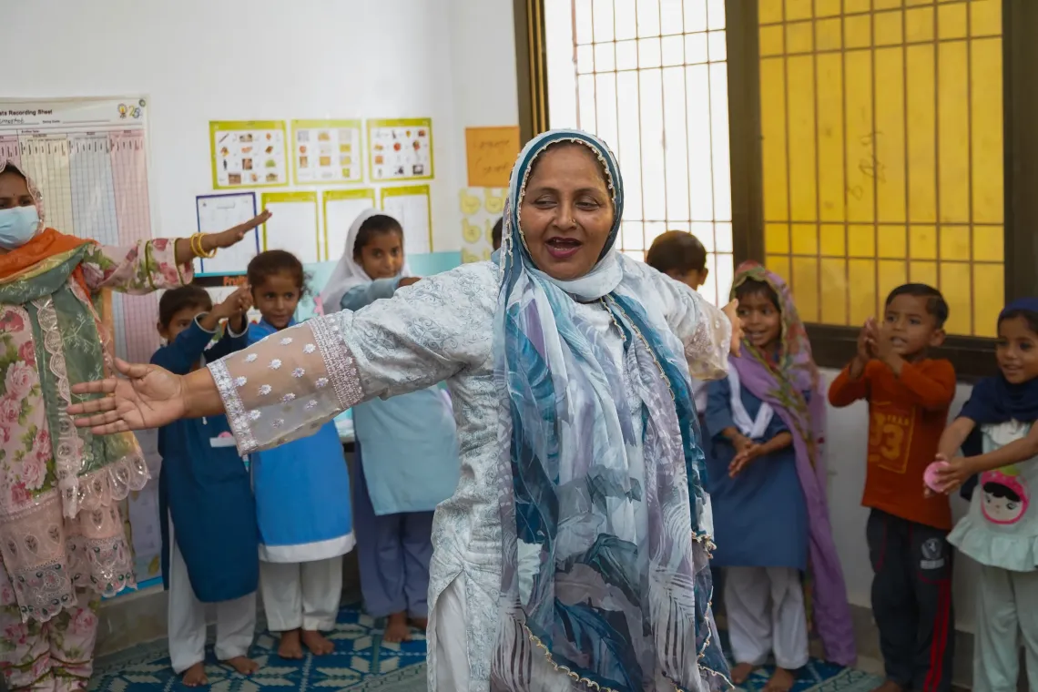 Parveen joyfully sings with students in a classroom in Umerkot, 