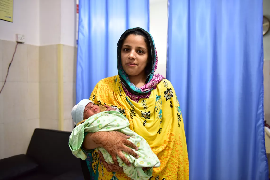Komal Fahad holding her infant son at the hospital