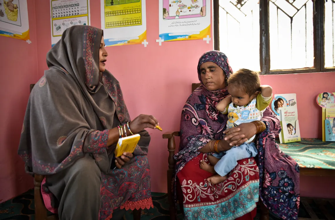 Kausar visits a lady health worker with her child