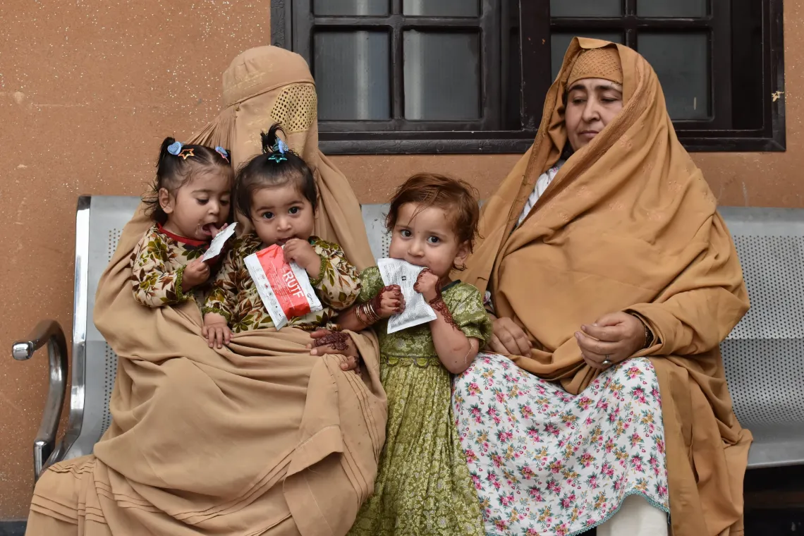 Dilbara Bibi and Zaiba Khan wait at the Civil Dispensary in Nazar Bostan, Peshawar, with Safa, Shifa, and Huma. The family is visiting for a follow-up session with a nutritionist, as Safa continues her journey toward health with the help of Ready-to-Use Therapeutic Food (RUTF)