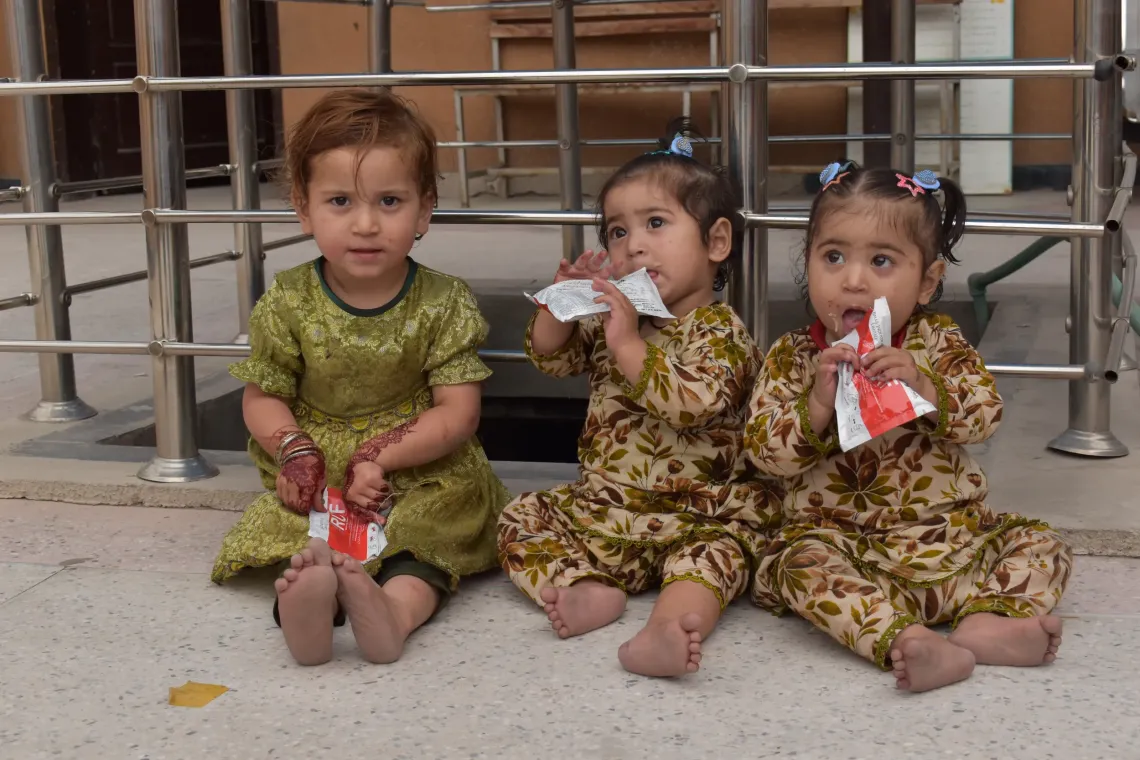 Three-year-old Huma joins 18-month-old twins Safa and Shifa as they receive RUTF nutritional support for their journey toward growth and recovery at Nazar Bostan Civil Dispensary, Peshawar, Khyber Pakhtunkhwa. 
