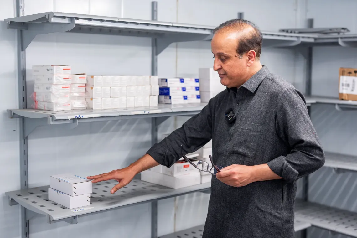 UNICEF Health Specialist Dr. Amir Akram checks the vaccines stored in the cold room situated in the warehouse in Uthal, Lasbela district. 