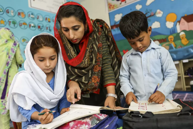Teacher Iram Akmal works with Muskan and Kanhaiya in class.