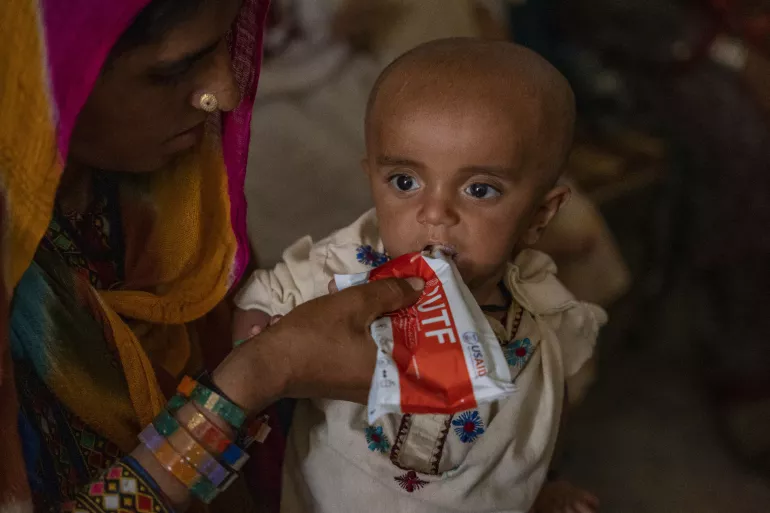 image of mother feeding her severely malnourished baby RUTF paste