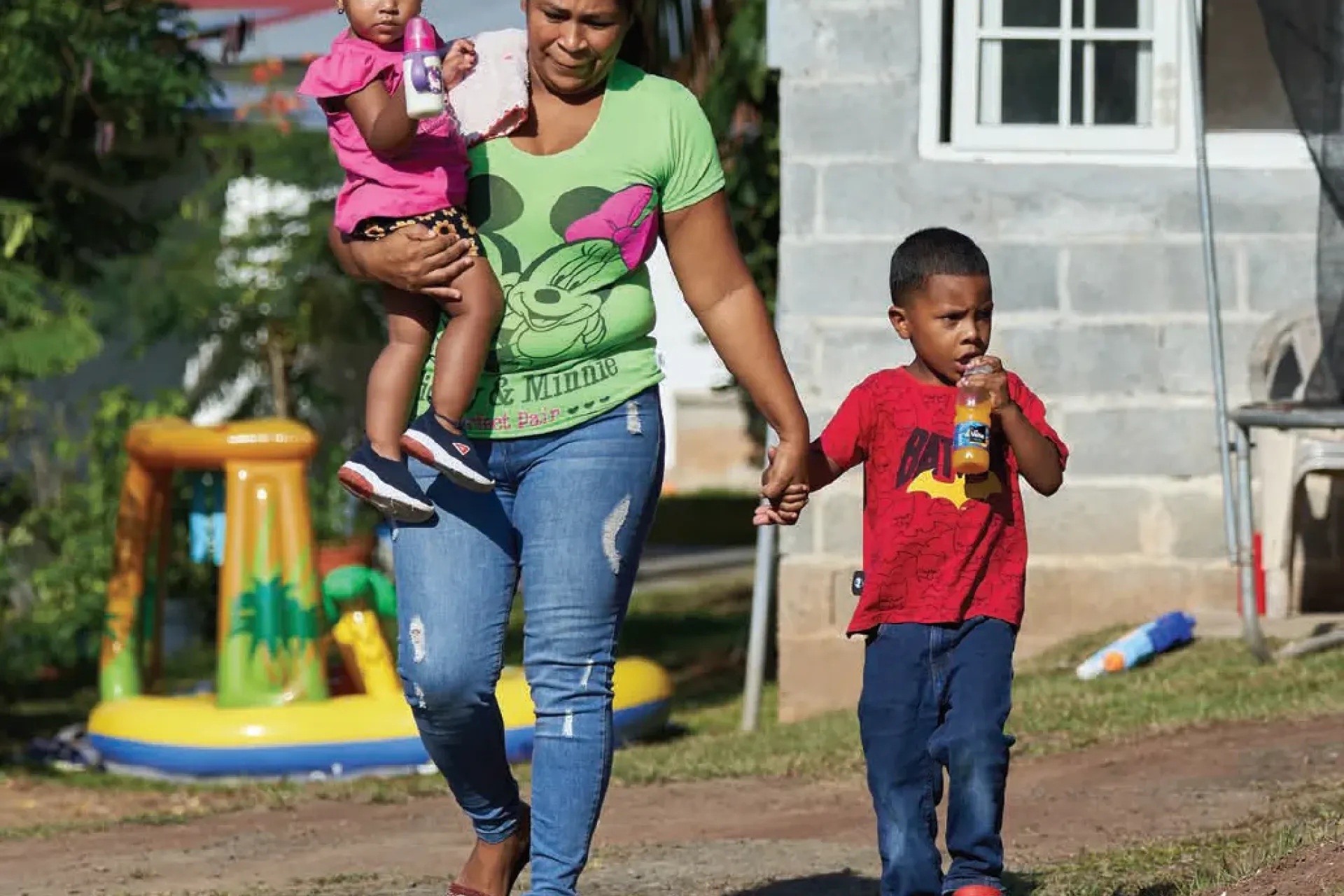 Una madre camina con sus dos hijos 