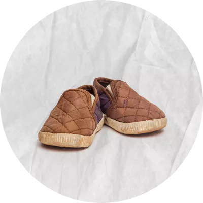 Zapatos tipo alpargatas de color marr&oacute;n, se ven gastados y sucios