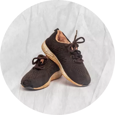 Zapatos negros con suelas blancas, se ven manchadas de tierra colorada