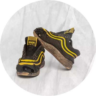 Zapatos negros con rayas amarillas, se ven gastado
