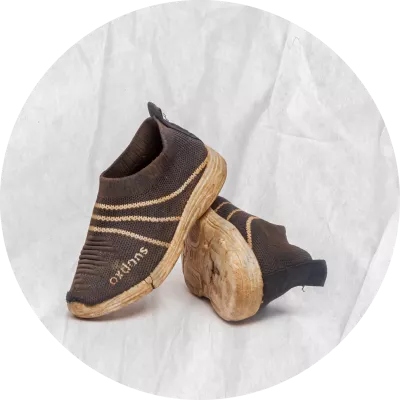 Zapatos deportivos de color negro con rayas blancas, se ven gastados.