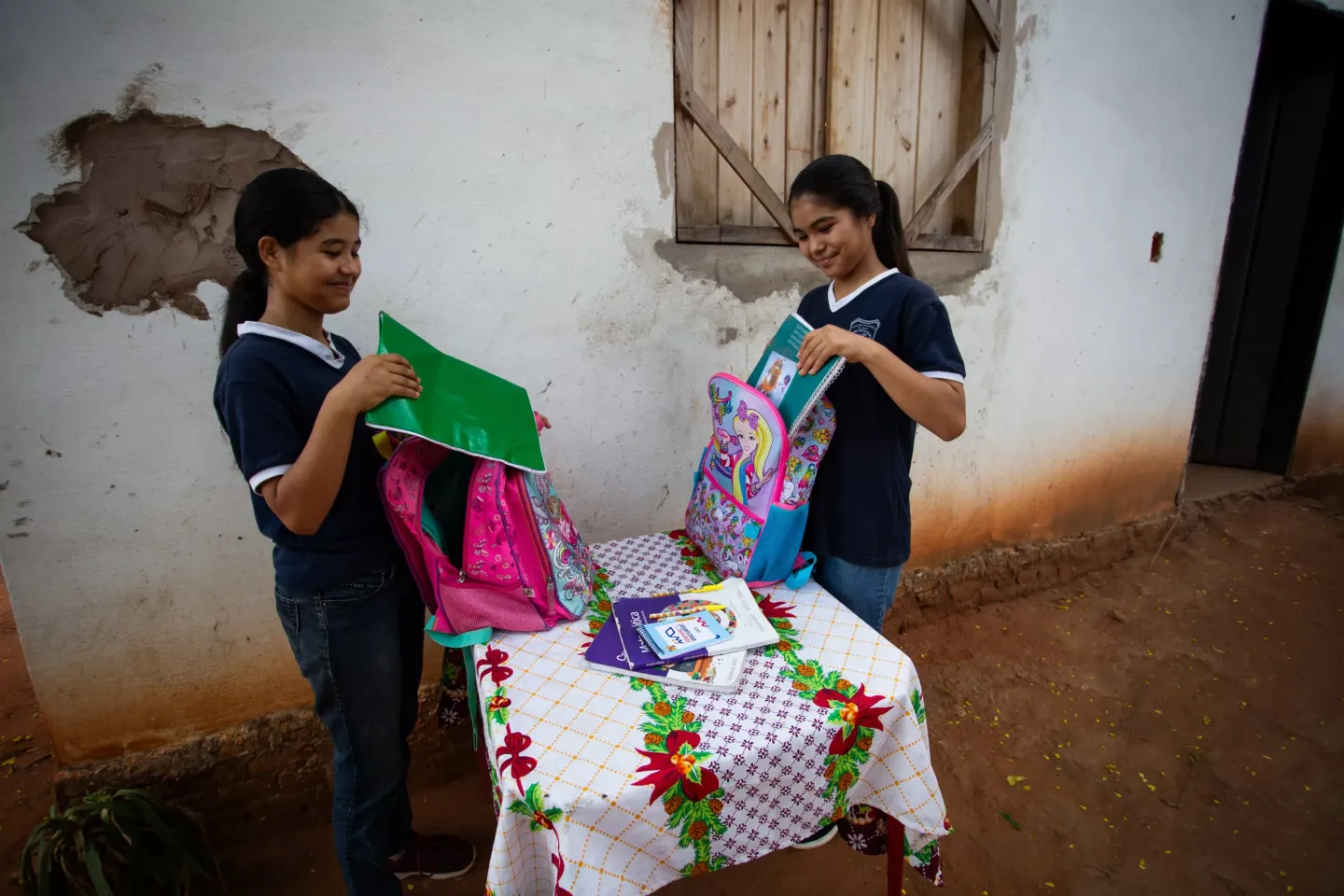 Faustina y Milena, dos ni&ntilde;as, guardan sus libros y cuadernos escolares en sus mochilas