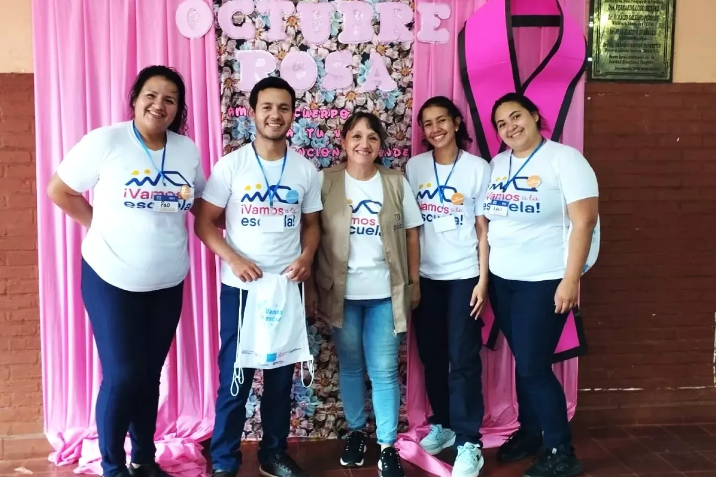 Cuatro mujeres y un hombre posan para la fotograf&iacute;a, tienen remeras del proyecto &iexcl;Vamos a la escuela!
