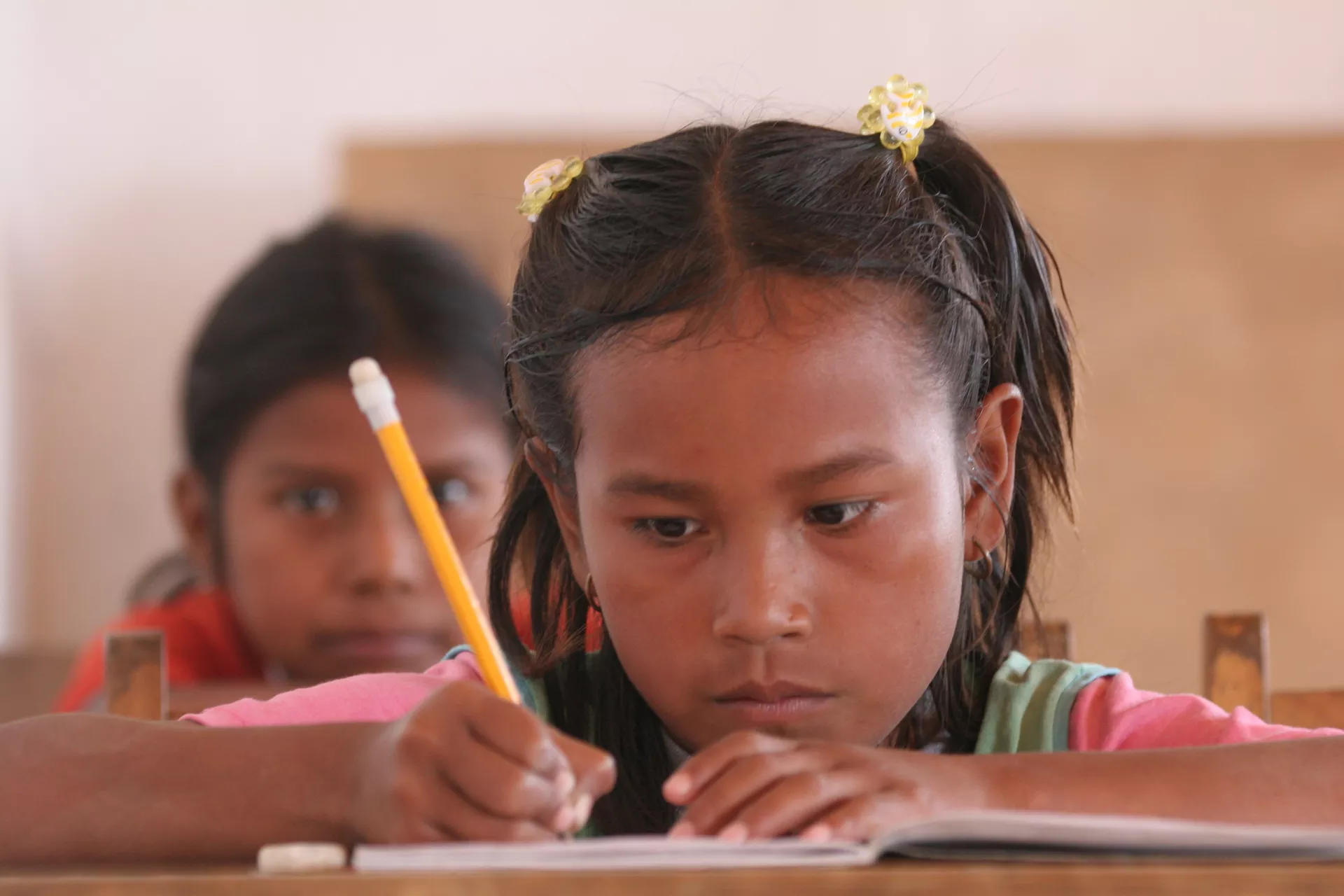 Ni&ntilde;a escribiendo con un l&aacute;piz de papel