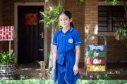 Ni&ntilde;a posa sonriente en el patio de la escuela