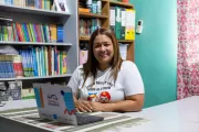Una mujer sonriendo con un computador en frente