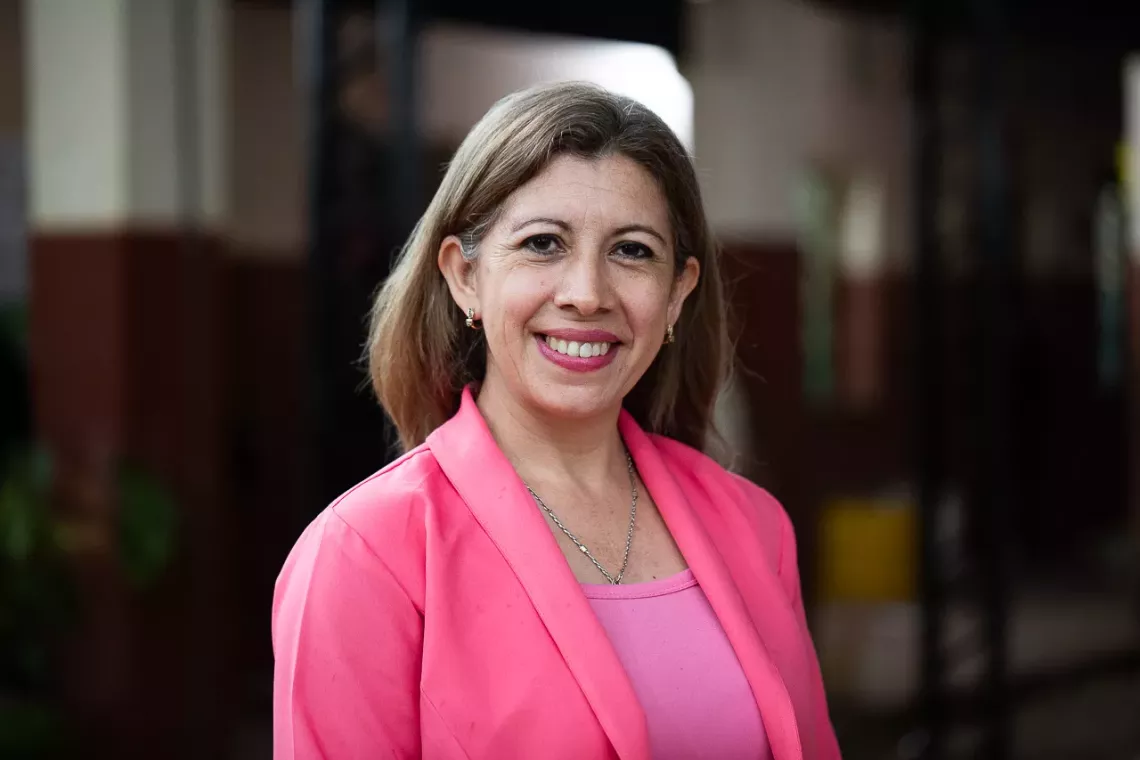 Mujer con traje color salm&oacute;n sonriendo
