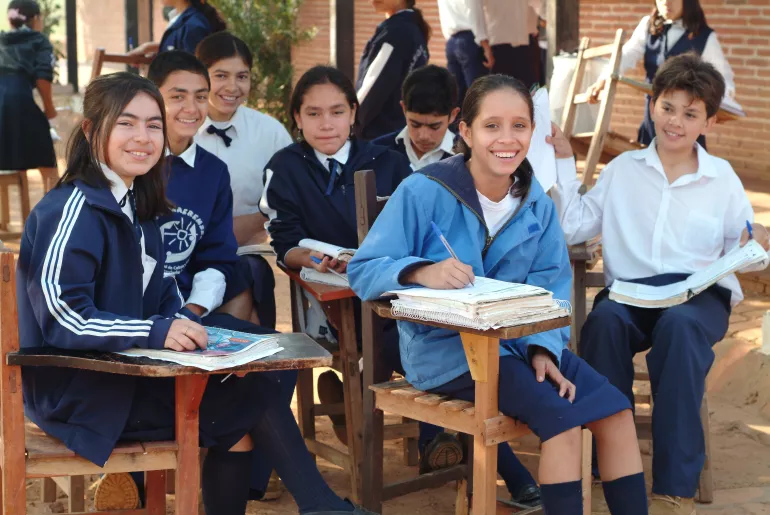 Estudiantes posan en sus pupitres.