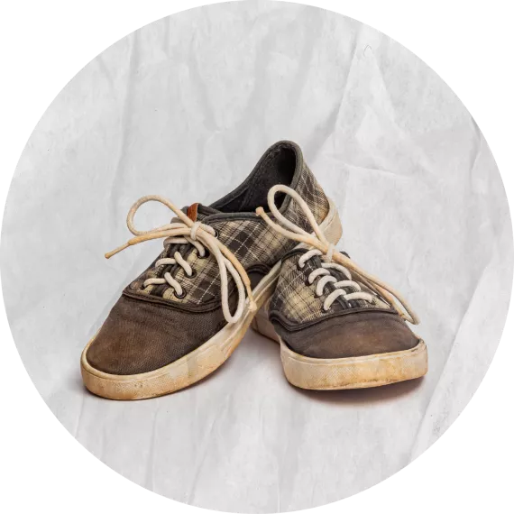Zapatos con cordones, con rayas, se ven gastados. 