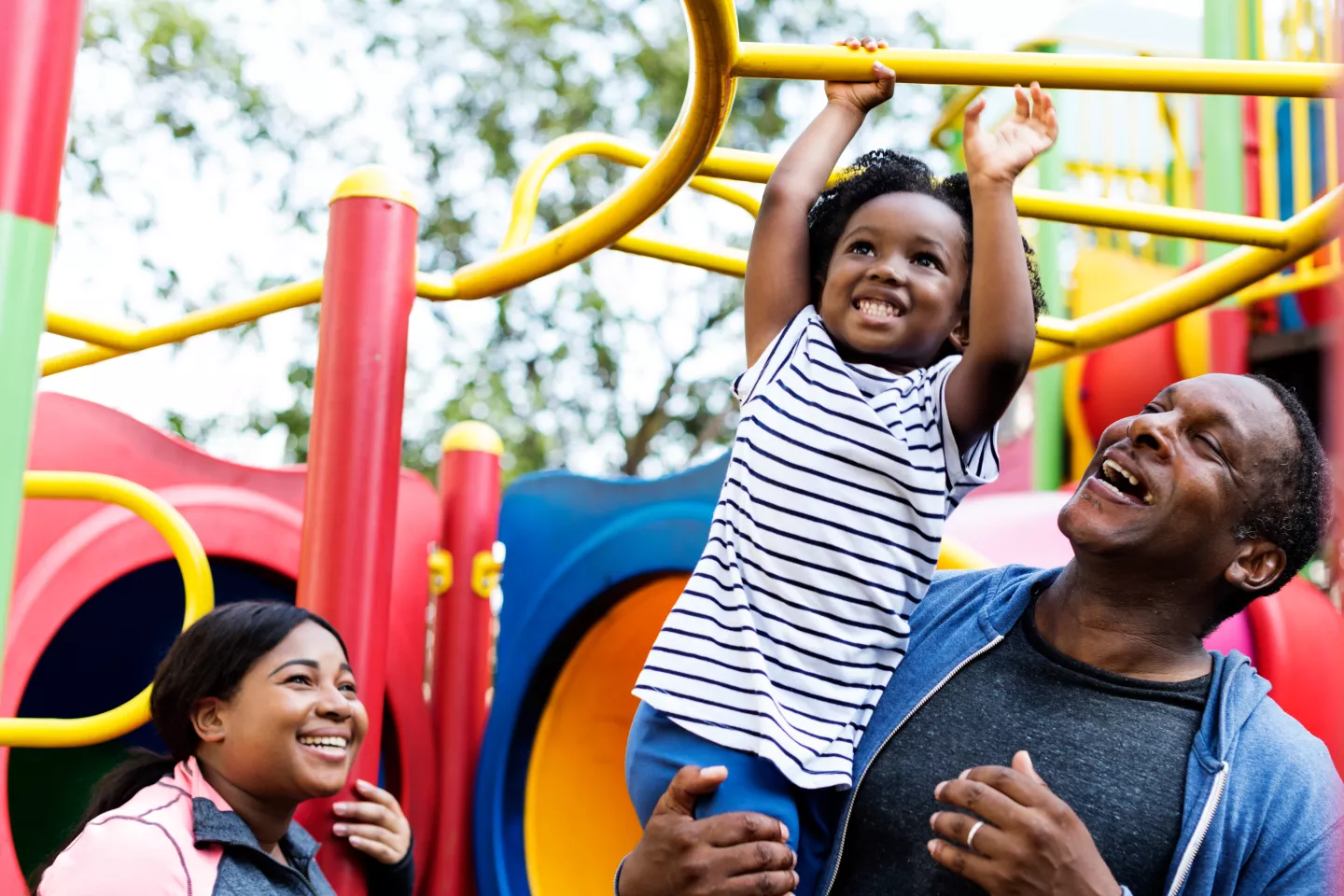 A girl plays with her mother and father