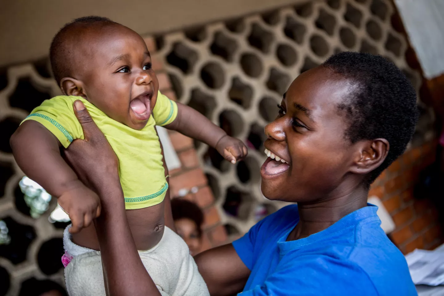 A mother holds her child up as she queues with others to register her child's birth and receive birth certificate from a registrar at the Chipata Clinic, Lusaka, ZambiaA mother holds her child up as she queues with others to register her child's birth and receive birth certificate from a registrar at the Chipata Clinic, Lusaka, Zambia.