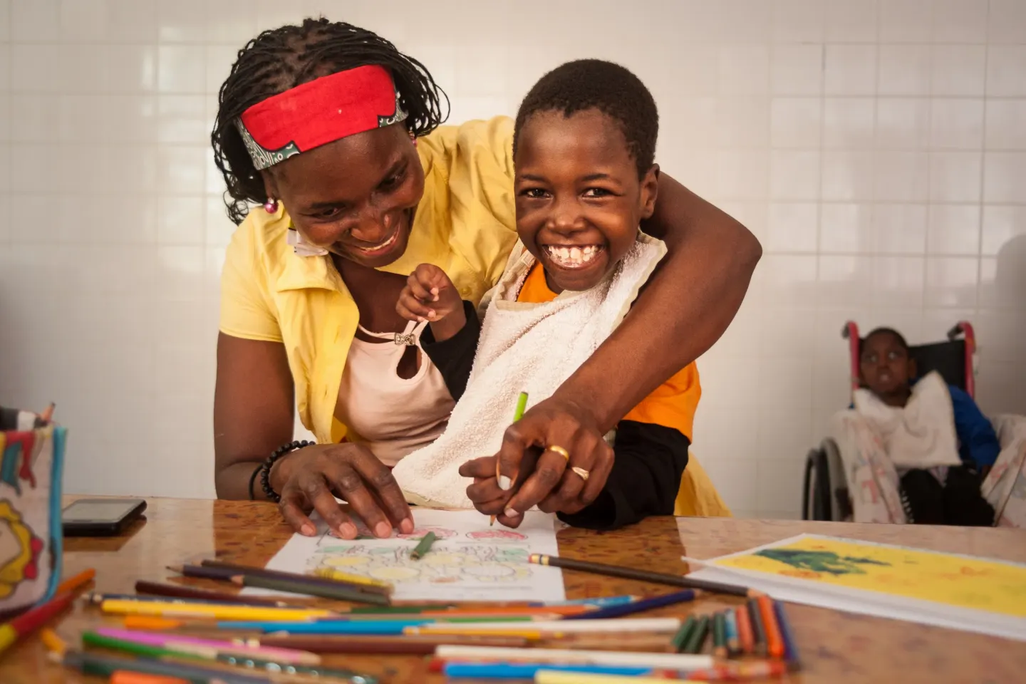 In Mozambique, Filomena and her mother draw a picture together at a UNICEF-supported centre for children with disabilities.