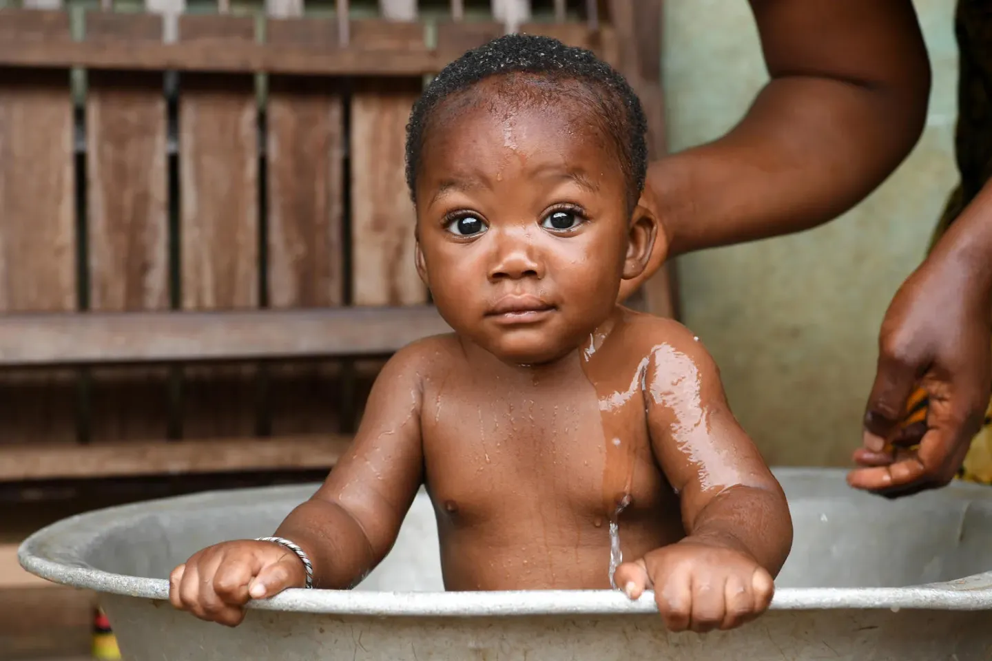 A baby gets a bath in C&ocirc;te d'Ivoire.