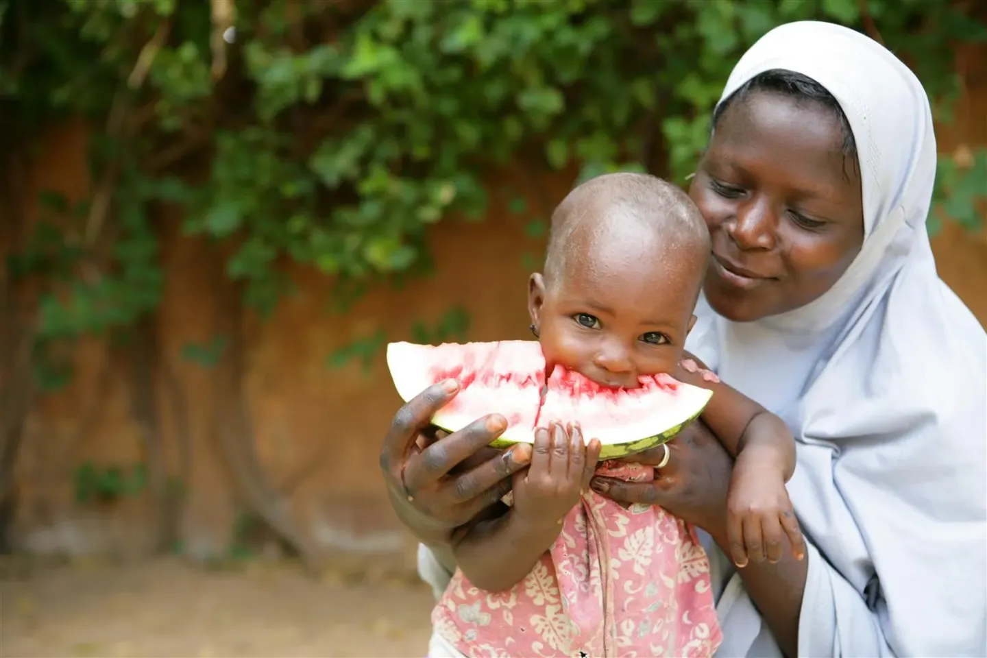 A mother holds her child while eating a slice of watermelon in Niamey the capital of Niger.