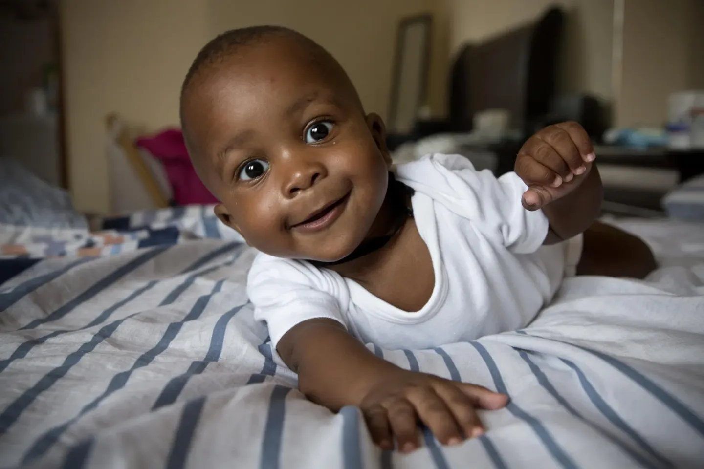 Abaleng Jaiden, one of four quadruplets, crawls on his parents' bed at the family's home in Gaborone, Botswana.