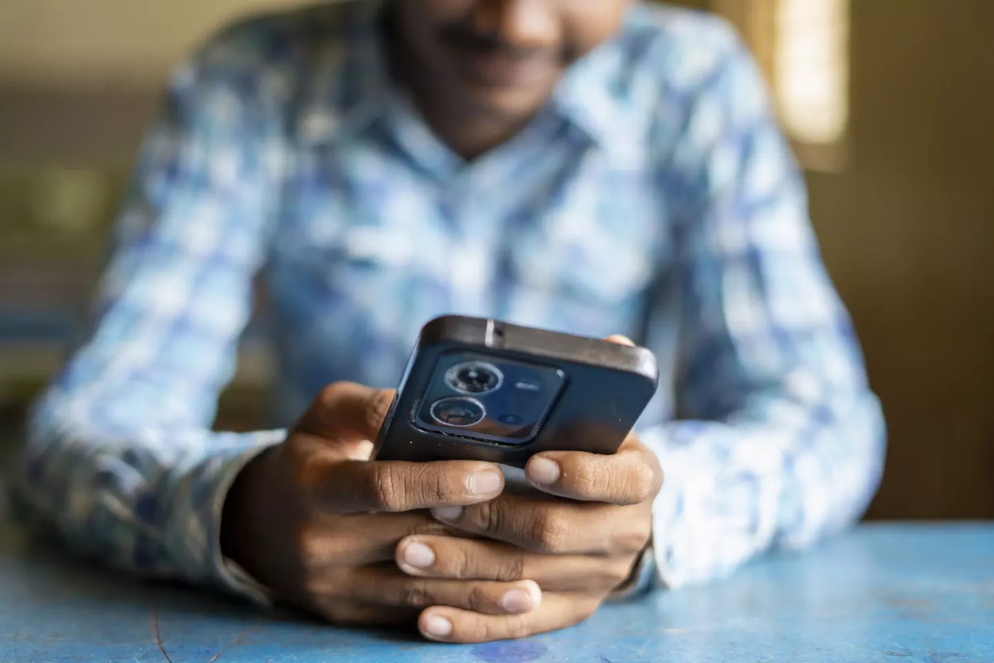 A teen holds a mobile phone in India