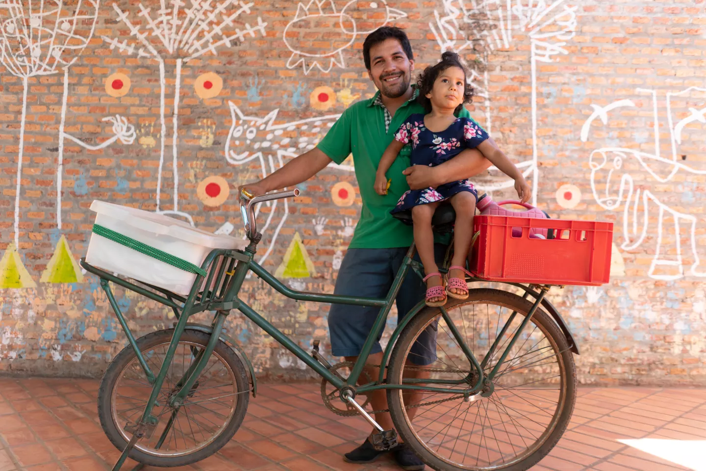 Parenting in Paraguay: a father holds his 2-year old daughter atop the bicycle that serves as the family's transportation and mobile food-sales cart 