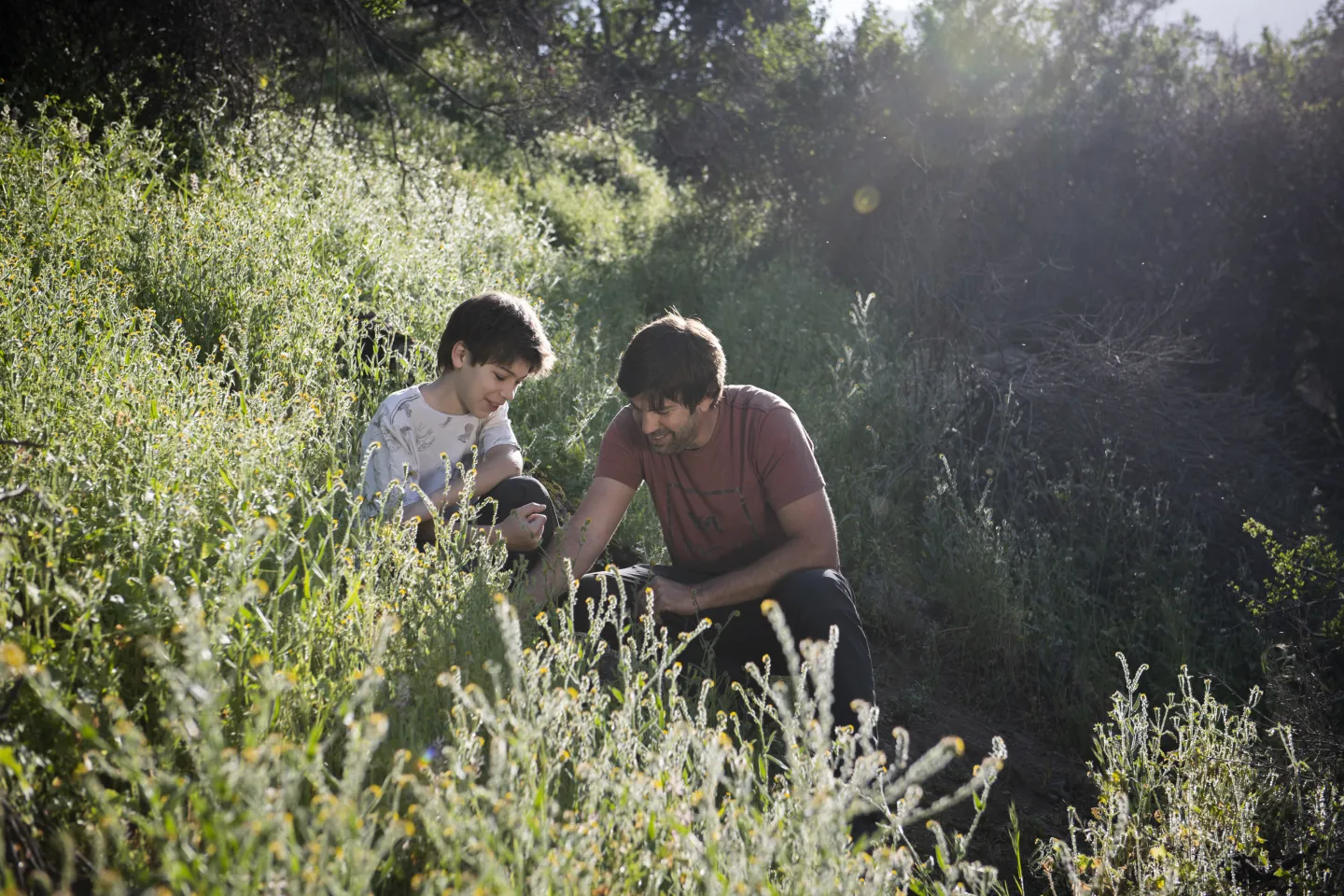 A 12 year old boy with his father in the outdoors. 