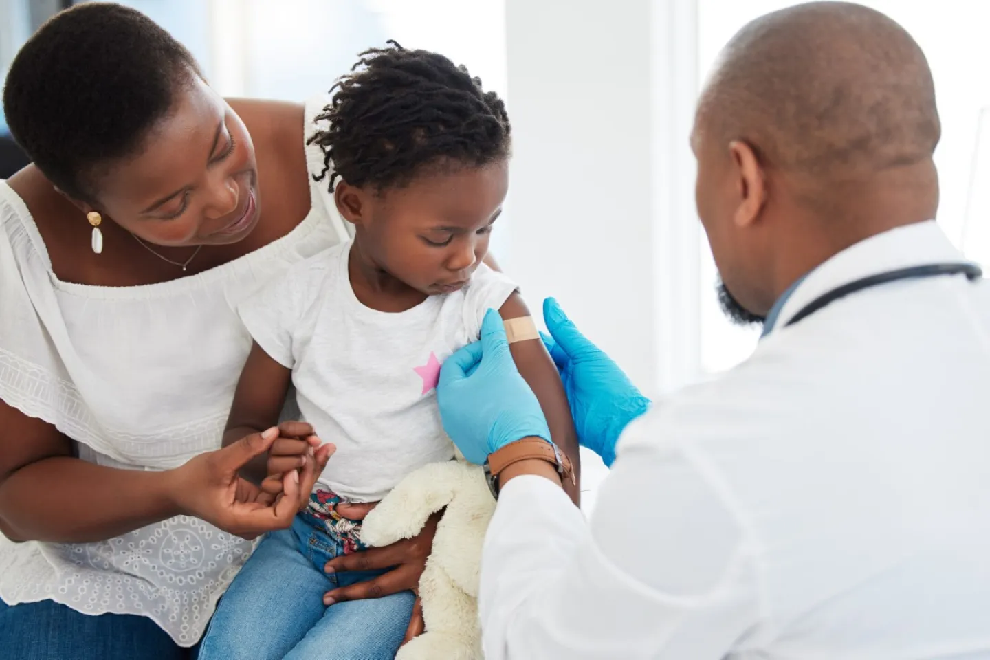 Little girl gets bandage after receiving vaccine.