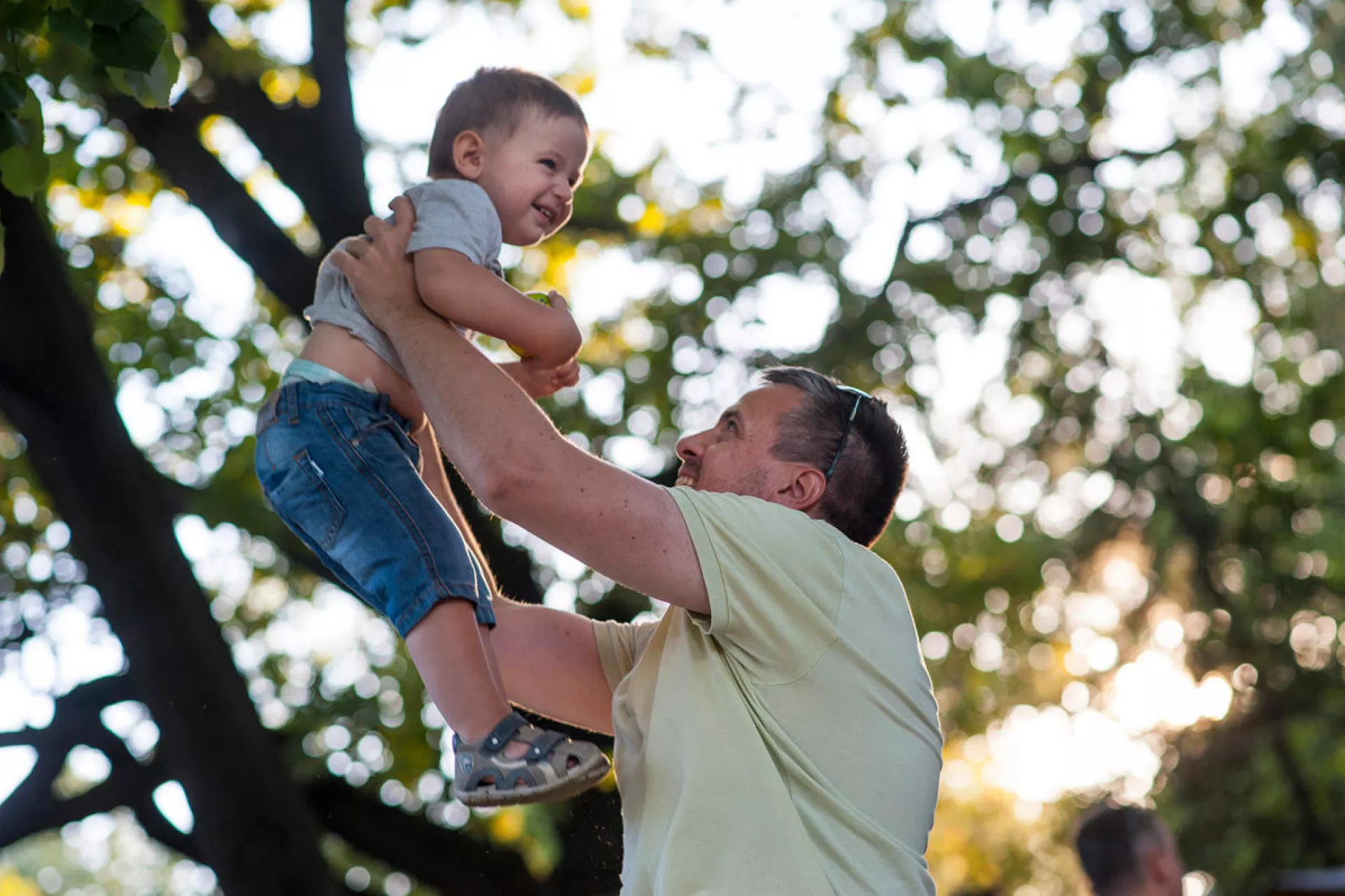 family mental health and well-being: a father plays with his son outside