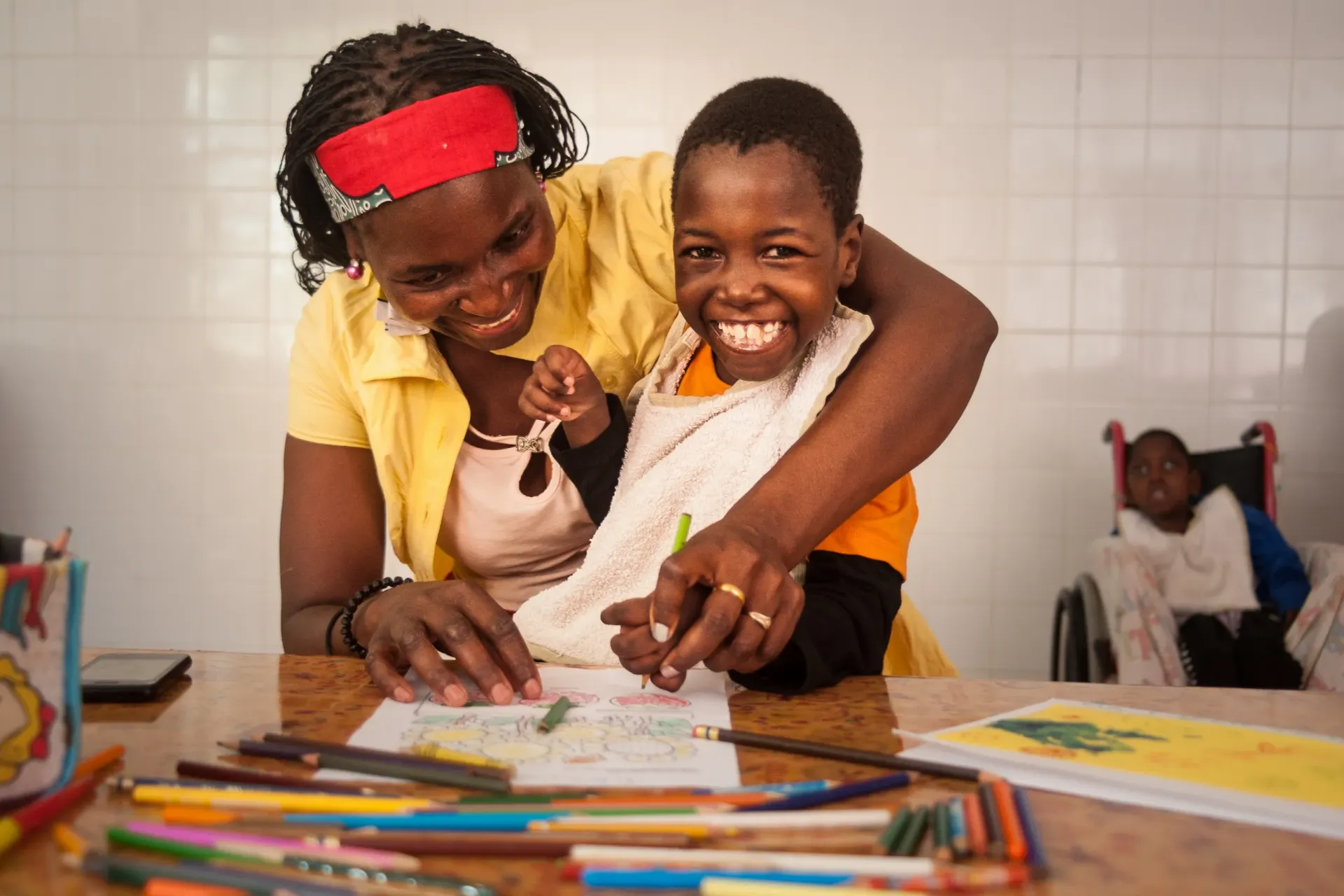 In Mozambique, Filomena and her mother draw a picture together at a UNICEF-supported centre for children with disabilities.