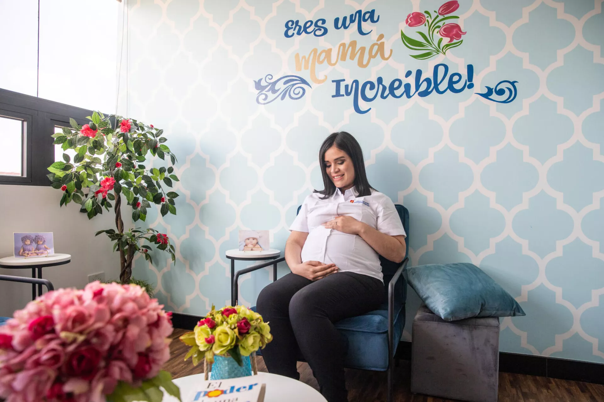 An expectant mother looks at her growing belly while sat in a breastfeeding room provided by her company in Guatemala  