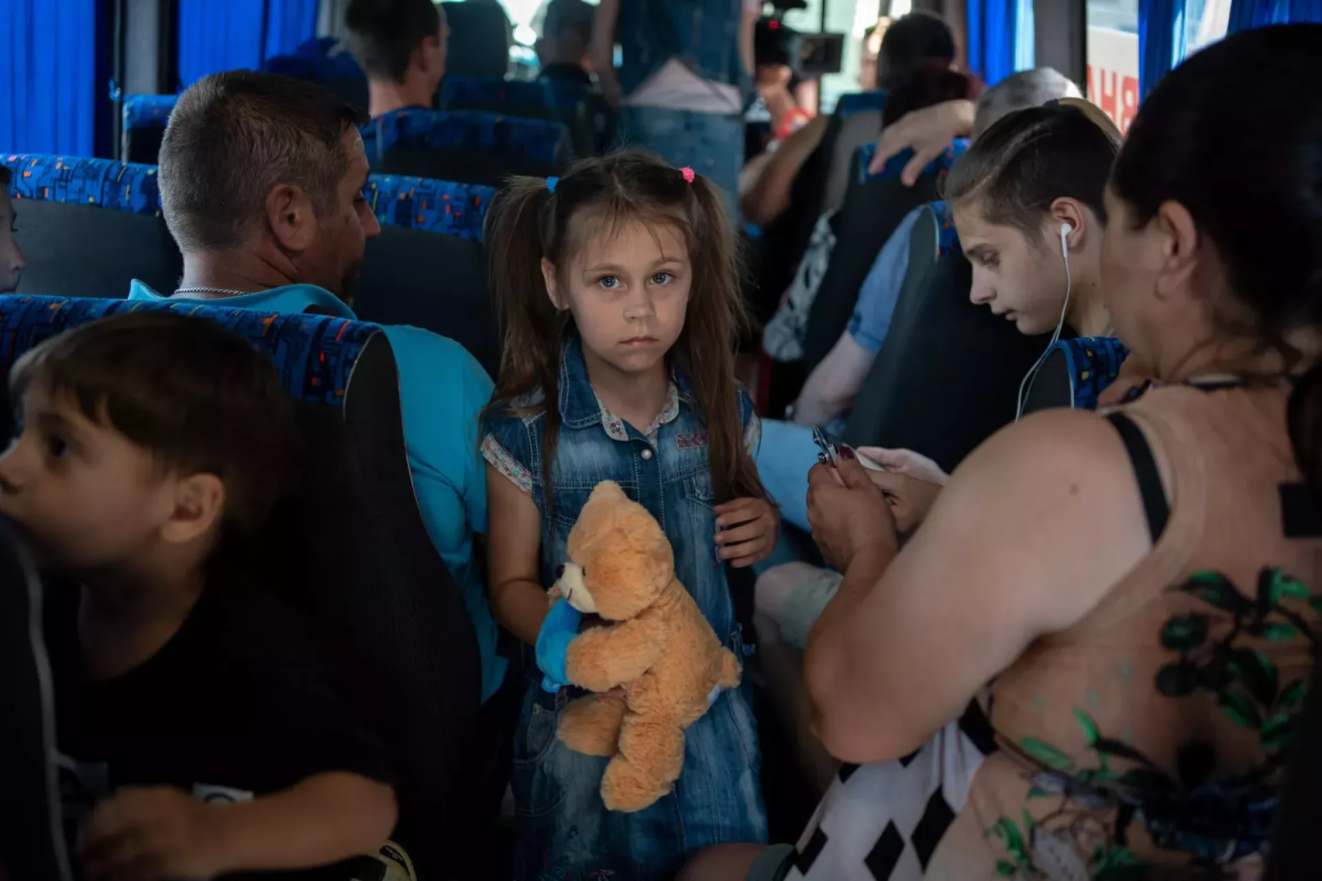A girl and her family are on an evacuation bus in Ukraine, 2023.