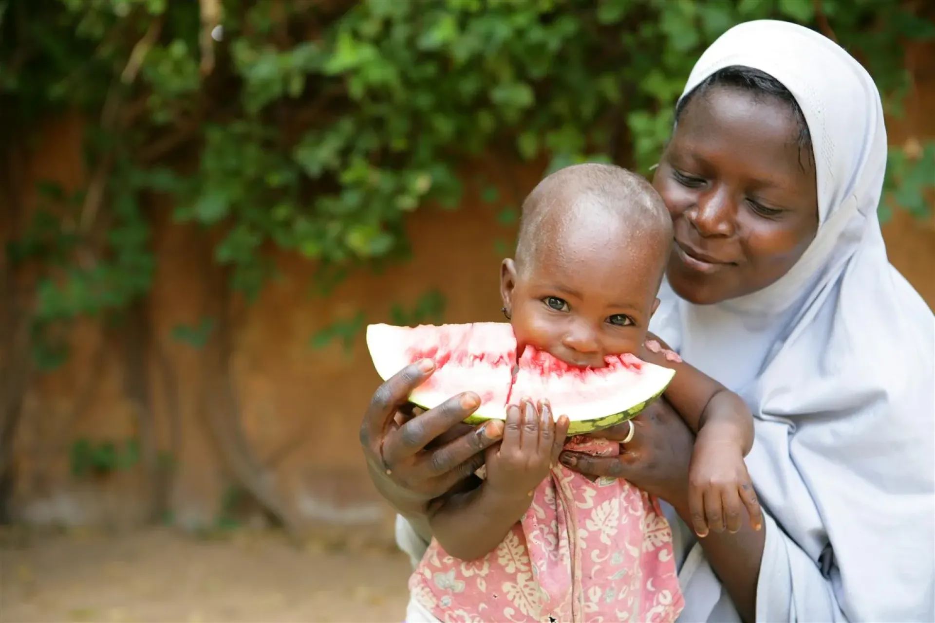 A mother holds her child while eating a slice of watermelon in Niamey the capital of Niger.
