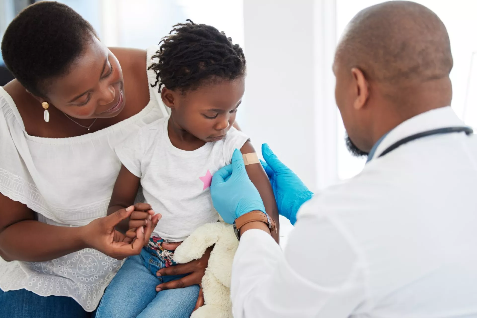 Little girl gets bandage after receiving vaccine.