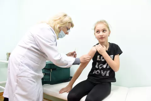 A girl receives an MMR vaccine, Ukraine.