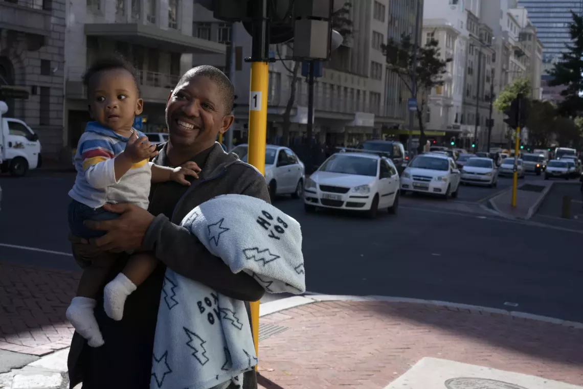 Bongani Ngqame, 44, holds his son, Khuma, 8 months, on a street near his office at the Department of Health in central Cape Town, South Africa.