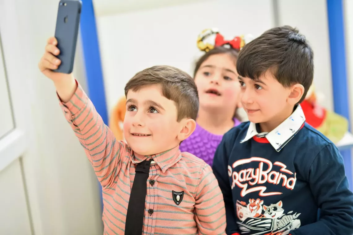Online privacy - a group of children take a selfie photo together