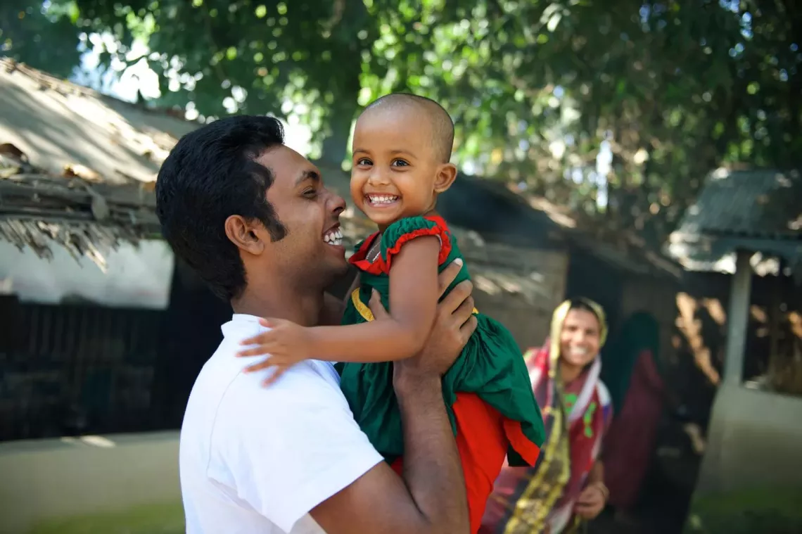 A girl is held up in the air by her uncle in India