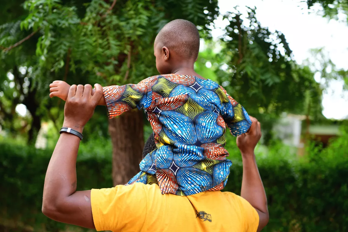 A father and child playing outside, in the garden of the Saint Camille Hospital, in Ouagadougou, the capital of Burkina Faso.