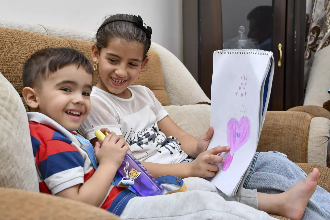 Two children draw together