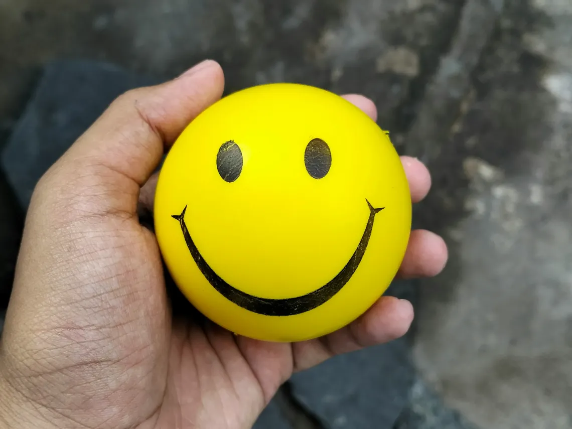 A yellow stress ball with a smiley face
