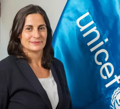 Ana de Mendoza, Representante, frente a una bandera de UNICEF