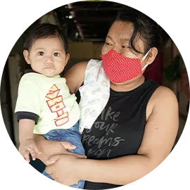 Una madre, usando mascarilla, sostiene a su beb&eacute;