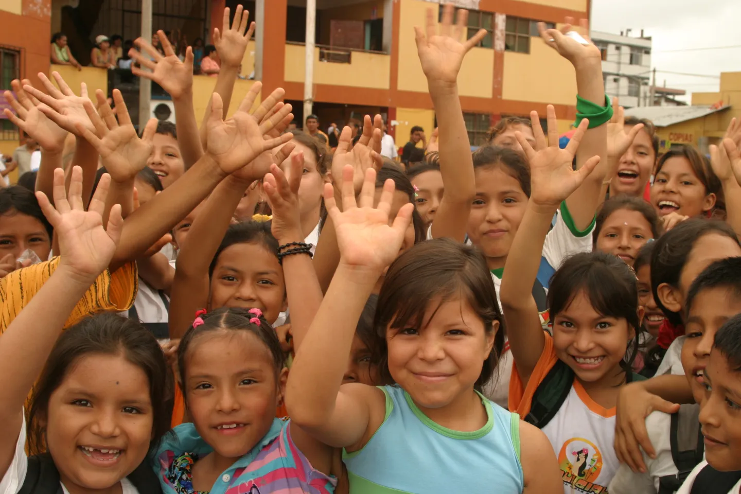 Ni&ntilde;os levantando las manos