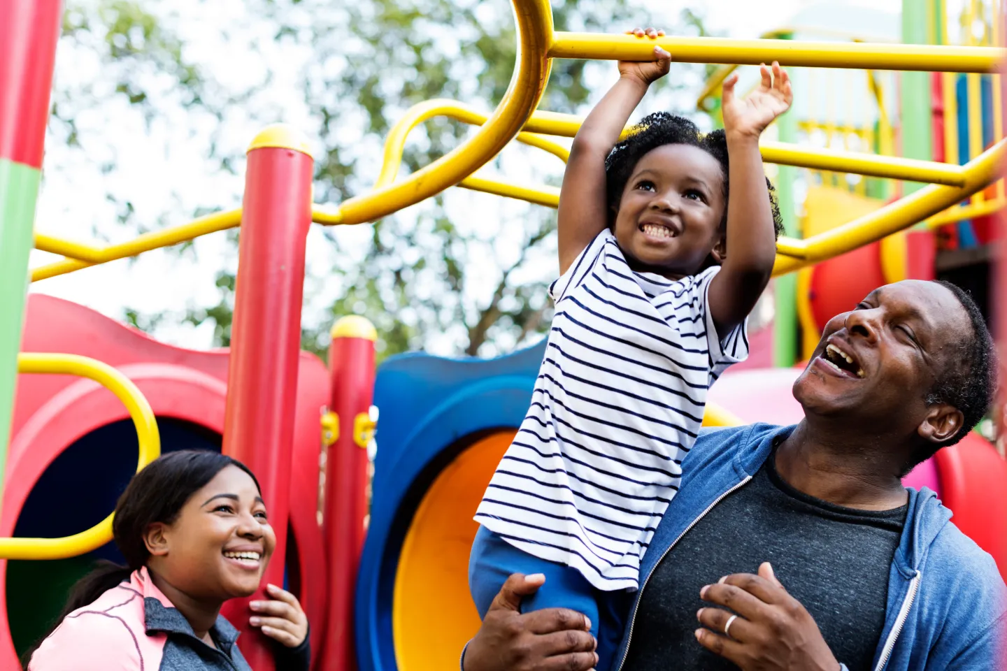 Una ni&ntilde;a juega en el parque con sus padres